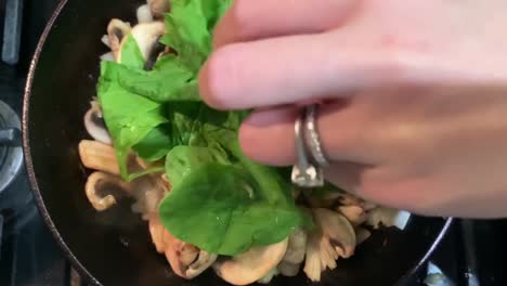 Kochen-Von-Pilzen,-Zwiebeln-Und-Grünem-Spinat-Mit-Einer-Gusseisernen-Pfanne