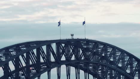 National-flags-of-Australia-sway-in-wind-on-top-of-famous-Harbour-Bridge-in-Sydney
