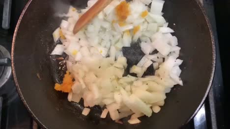 Cooking-onions-with-minced-garlic-and-olive-oil-over-a-hot-cast-iron-skillet