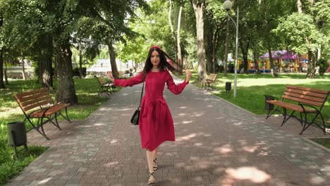 Gorgeous-brunette-in-red-walking-in-the-park