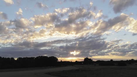Herrlicher-Sonnenuntergang-Und-Bewölkter-Himmel-Landschaft-über-Der-Grünen-Wiese-Und-Den-Maisfeldern-Auf-Dem-Land