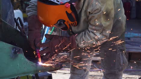 Man-Working-as-Blacksmith-wearing-a-Security-Mask-and-Welding-with-Blow-Torch---Slowmotion