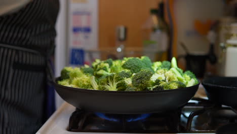 Sprinkling-salt-on-a-skillet-full-of-broccoli-as-it-cooks-on-the-stove-top---slow-motion