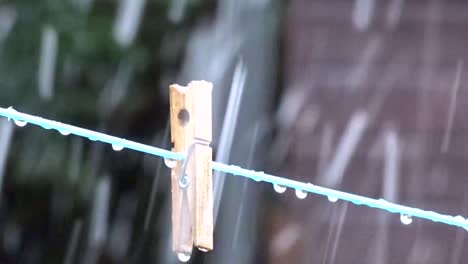 Close-up-of-snow-falling-past-a-solitary-peg-on-a-washing-line