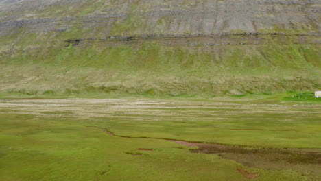 Slow-pan-right-over-basin-in-Hornvik-Bay-reveals-lone-yellow-cottage