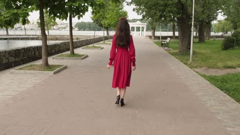 Beautiful-positive-girl-walks-in-the-park-near-the-lake
