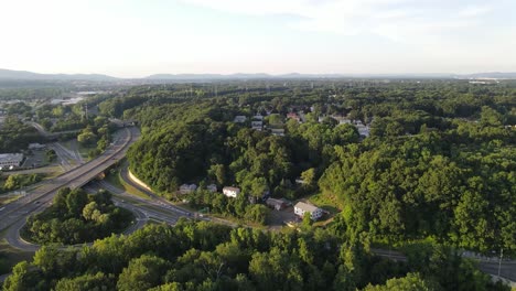 Drone-shot-flying-over-trees-reviling-street-and-highway-24fps