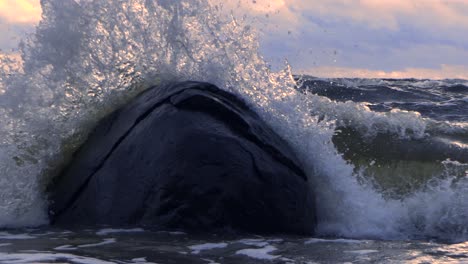 Wellen-Im-Meer-Während-Eines-Gewitters-Bei-Sonnenuntergang,-Große-Steine-Am-Meeresufer