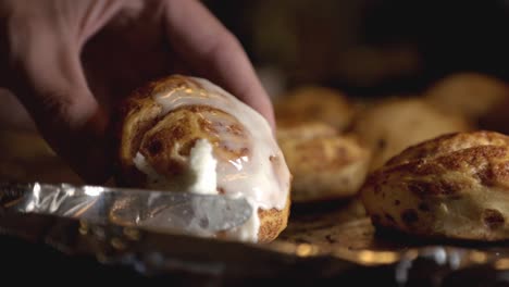 Spreading-White-Icing-On-Top-Of-A-Cinnamon-Bread-With-A-Bread-Knife---close-up-slowmo