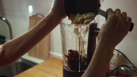 Woman-puts-fried-almond-into-blender