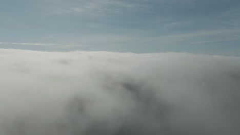 Luftflug-über-Dicken-Grauen-Geschwollenen-Wolken-Mit-Blauem-Himmel-Im-Hintergrund