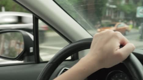 Close-up-of-woman's-hands-on-the-wheel-of-a-car-driving