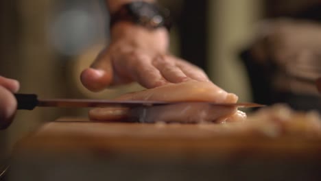 Kochen-Sie-In-Der-Küche-Und-Schneiden-Sie-Das-Brusthähnchenfilet-Mit-Einem-Scharfen-Messer-In-Zwei-Hälften