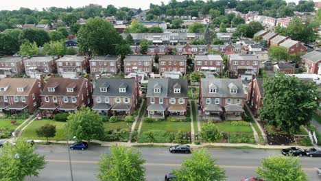 Aerial-of-brick-and-brownstone-urban-homes-in-New-York-City-boroughs,-Queens,-Bronx-establishing-shot-during-quiet-summer