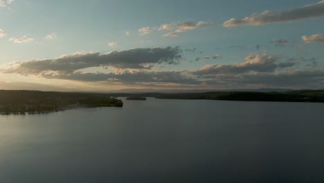 Aerial-parallax-view-of-Lake-Otis-and-clouds-in-golden-summer-sunset-light