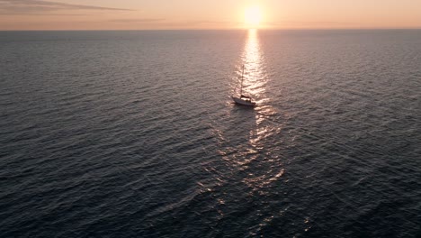 Ein-Einsames-Segelboot,-Das-Auf-Den-Offenen-Wassern-Von-Saint-Lawrence-Kreuzt,-Mit-Einem-Malerischen-Blick-Auf-Den-Himmel-Bei-Einem-Sonnenaufgang-In-Quebec,-Kanada