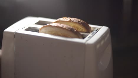 Zwei-Scheiben-Weizenbrot,-Die-Aus-Einem-Weißen-Toaster-Herausspringen