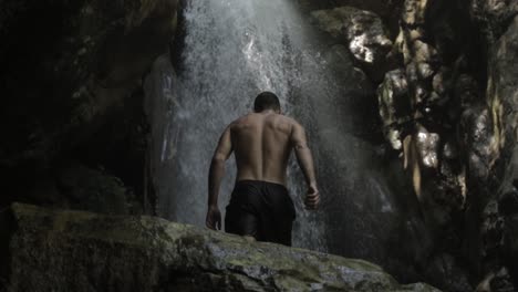 Rückansicht-Des-Jungen-Mannes-Geht-In-Richtung-Majestätischer-Wasserfall,-Libanon,-Tag,-Neigung-Nach-Unten