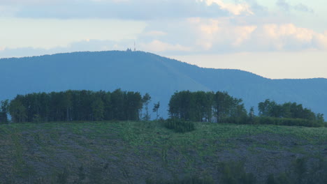 The-top-of-the-hill-with-trees-and-in-the-background-you-can-see-a-mountain-with-a-transmitter-on-its-top-Radhost-area-of-Beskydy