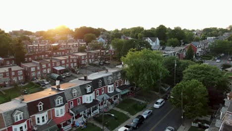 Aerial-establishing-shot-of-early-1900s-homes-in-United-States-city,-urban-low-income-housing-projects-during-sunrise
