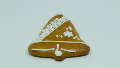 Zoomed-in-confectionery-gingerbread-with-white-decoration-on-top-in-the-shape-of-a-bell-on-a-white-background