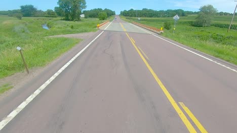 POV-thru-rear-view-window-while-driving-down-a-county-road-in-rural-South-Dakota