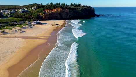 Revealing-drone-shot-at-Redhead-Beach-Australia,-starting-on-surf-then-rising