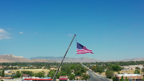 Flagge-Der-Vereinigten-Staaten-Von-Amerika-Und-Symbol-Der-Freiheit-Und-Des-Patriotismus,-Die-An-Einem-Sommertag-Hoch-über-Einer-Stadt-Fliegen---Zeitlupe