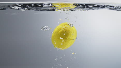 Zitrone-Fällt-Ins-Wasser.-Nahaufnahme,-Zeitlupe