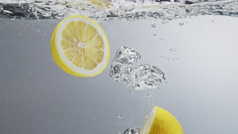 Two-lemon-halfs-falling-in-clear-fresh-water
