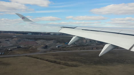 Pov-Flugzeug:-Ansicht-Des-Flugzeugflügels,-Der-Flachen-Landschaft-Und-Der-Landung-Am-Flughafen,-Helsinki,-Finnland,-Handgerät