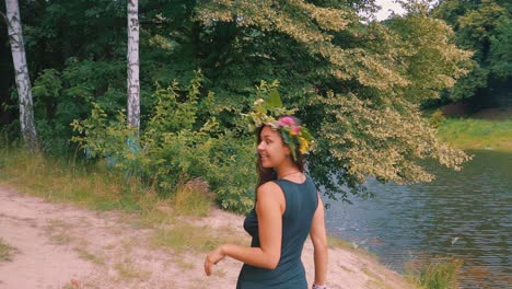 Slow-Motion-of-Happy-Sensual-Young-Woman-With-Wreath-of-Flowers-by-Lake-and-Tree