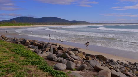 Surfers-Walking-Away-From-The-Ocean-After-Surfing---Summer-Day-At-The-Beach-In-Crescent-Head-In-New-South-Wales---wide-shot