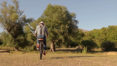 Joven-Guapo-Hipster-Montando-En-Bicicleta-En-La-Naturaleza