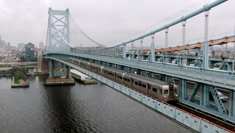 Commuter-subway-el-train-leaves-Philadelphia,-Pennsylvania,-on-Ben-Franklin-Bridge,-en-route-to-Camden,-New-Jersey