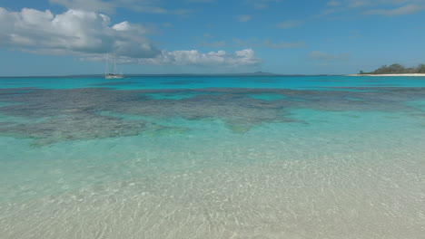 Velero-Anclado-En-Arrecifes-De-Coral-En-Isla-De-Pinos,-Nueva-Caledonia