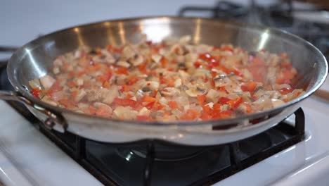 Vegetarian-mix-sizzling-in-a-skillet-on-a-stove-top---slow-motion