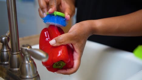 Washing-a-sweet-bell-pepper-in-the-kitchen-sink---slow-motion