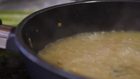 Frying-Pan-Close-Up-With-Broth-Bubbling-And-Emitting-Vapor-Dolly-Shot