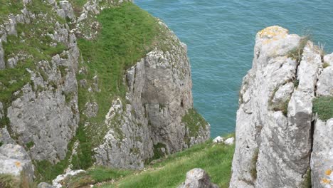 Grassy-rocky-Great-Orme-cliff-edge-mountain-edge-view-looking-down-to-scenic-sea-view