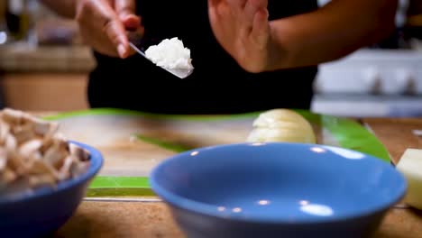 Tossing-diced-onions-in-a-bowl-in-preparation-for-a-homemade-dish-in-slow-motion