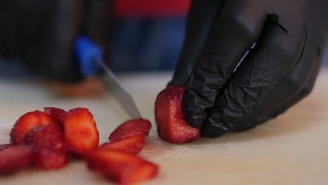 Nahaufnahme-Des-Schneidens-Frischer-Erdbeeren-Beim-Tragen-Von-Lebensmittelsicherheitshandschuhen