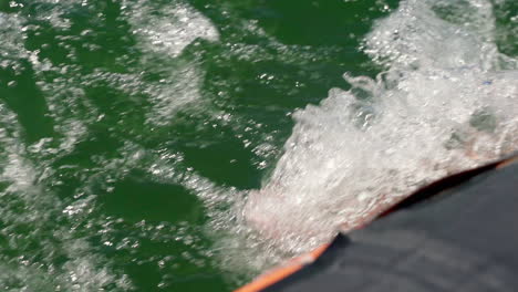 Water-Splashing-On-The-Feet-Of-A-Person-Cruising-On-A-Motorboat-During-Summer---extreme-close-up