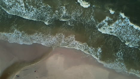 Birdseye-overhead-Drone-Aerial-over-Dirty-brown-Ocean-Waves-Crashing-against-the-shore,-Drone-Aerial