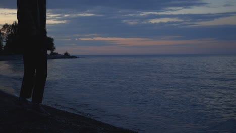 Mann,-Der-Am-Strand-Steht-Und-Während-Des-Sonnenuntergangs-Fotos-Auf-Dem-Ruhigen-Meer-Macht