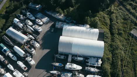 Aerial-Fly-over-aquatic-storage-yard-for-various-boats-fishing-deck-dinghy-bowrider-catamaran-cuddy-cabin-center-console-house-boats-trawlers-yachts-cabin-cruisers-while-some-are-getting-repaired-1-2