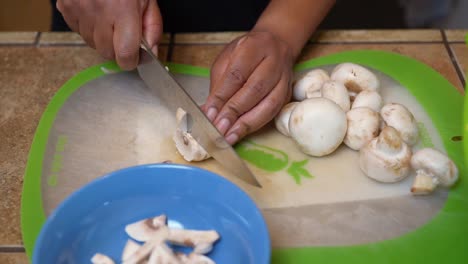 Slicing-fresh-mushrooms-for-a-homemade,-vegetarian-recipe---slow-motion
