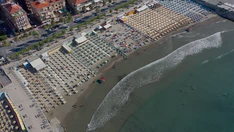 drone-descending-over-a-beach-in-Andora,-Liguria