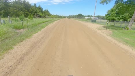 POV-out-the-rear-window-driving-on-gravel-road-in-the-countryside-of-South-Dakota