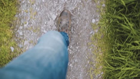 Man-in-blue-jeans-hiking-walking-on-stony-path-in-slow-motion---top-down-view-from-waist